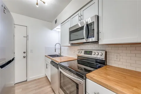 a kitchen with stainless steel appliances a stove a sink and a microwave