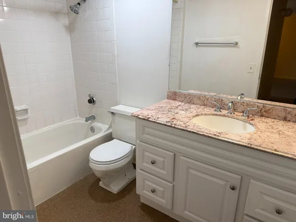 a bathroom with a granite countertop toilet a sink and a bathtub