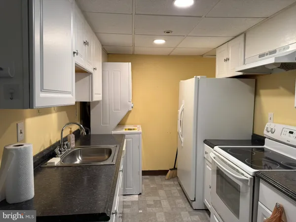 a kitchen with stainless steel appliances granite countertop a sink a refrigerator and a stove