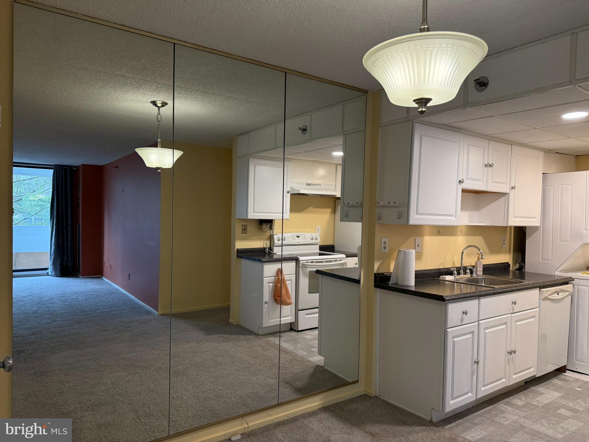 5911 Edsall Road, Unit 601 Alexandria, VA 22304 - Photo 7 of 14 a kitchen with kitchen island granite countertop a sink a counter space appliances and cabinets