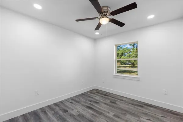 an empty room with a window and a fan