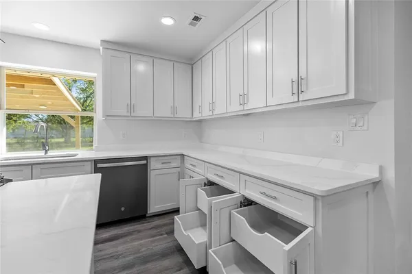 a kitchen with granite countertop white cabinets and white appliances