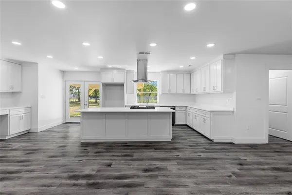 a view of kitchen with kitchen island white cabinets wooden floor and center island