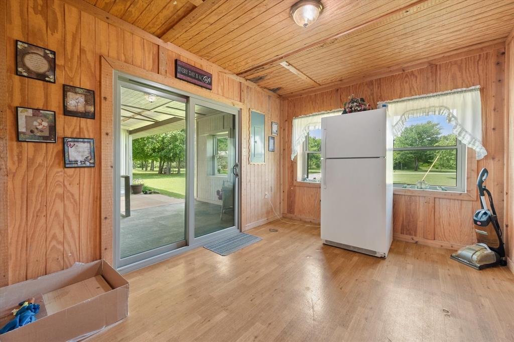 2101 Ridge View Drive Cleburne, TX 76033 - Photo 22 of 31 Interior space featuring wood-paneled walls and ceiling, wood-finish flooring, and two windows providing natural light