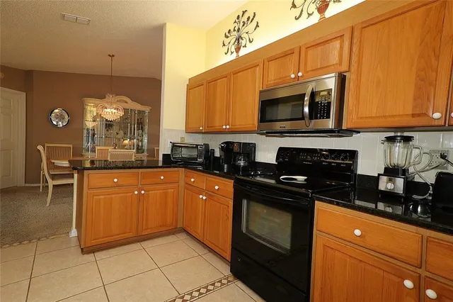a kitchen with stainless steel appliances granite countertop a stove a sink and a microwave