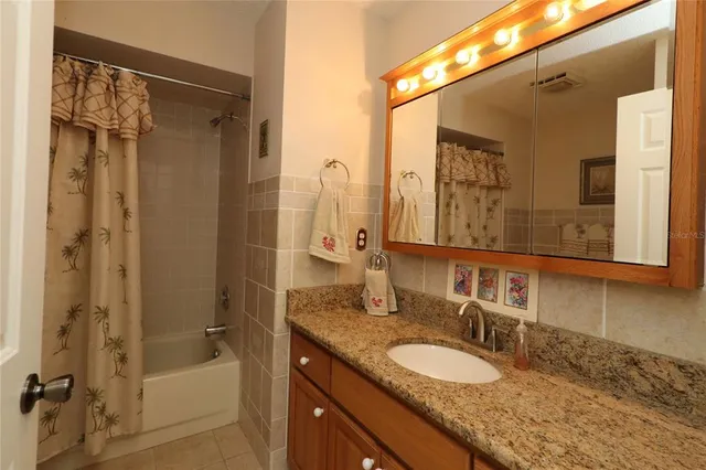 a bathroom with a granite countertop shower sink and mirror