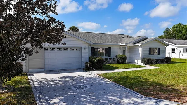 a front view of a house with yard and green space