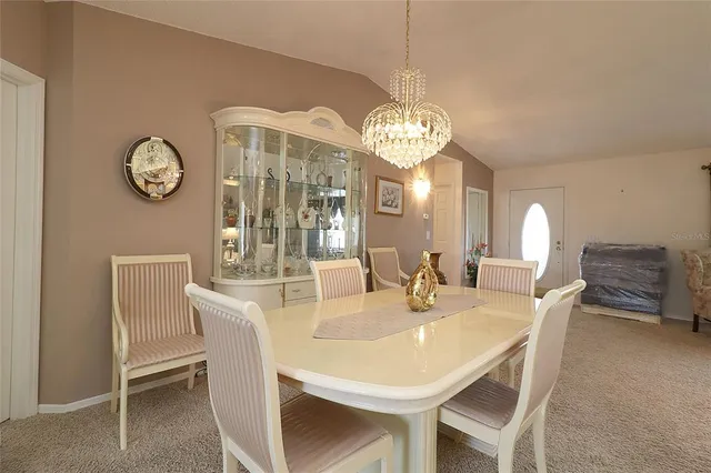 a view of a dining room with furniture a chandelier and wooden floor