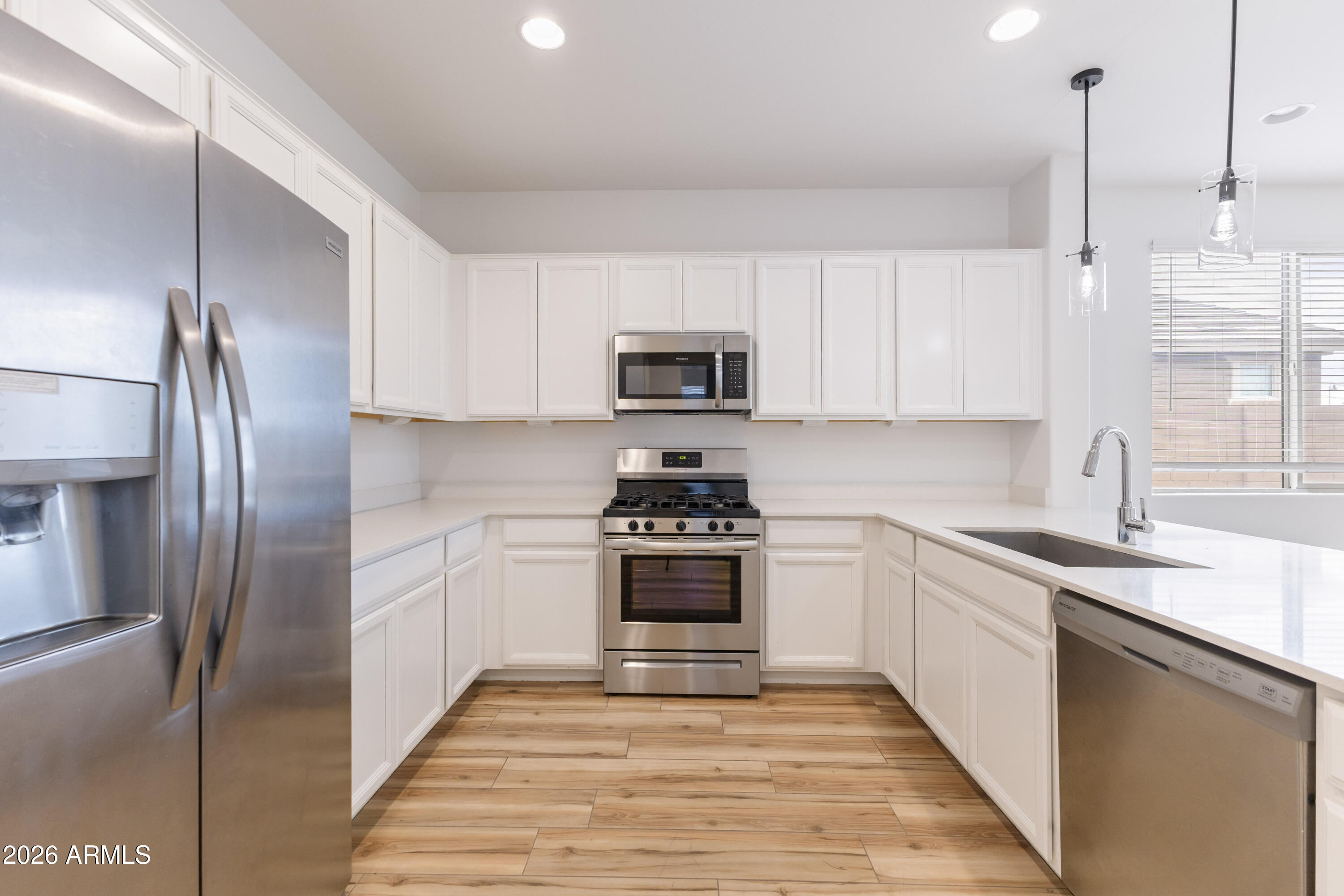 21303 East Estrella Road Queen Creek, AZ 85142 - Photo 11 of 32 a kitchen with stainless steel appliances granite countertop a stove a sink and a refrigerator