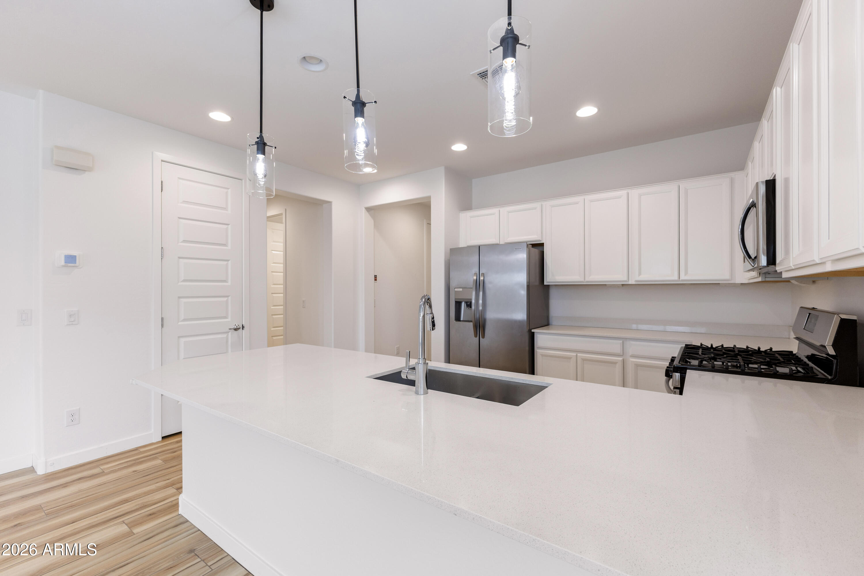 21303 East Estrella Road Queen Creek, AZ 85142 - Photo 12 of 32 a kitchen with stainless steel appliances a refrigerator sink and cabinets