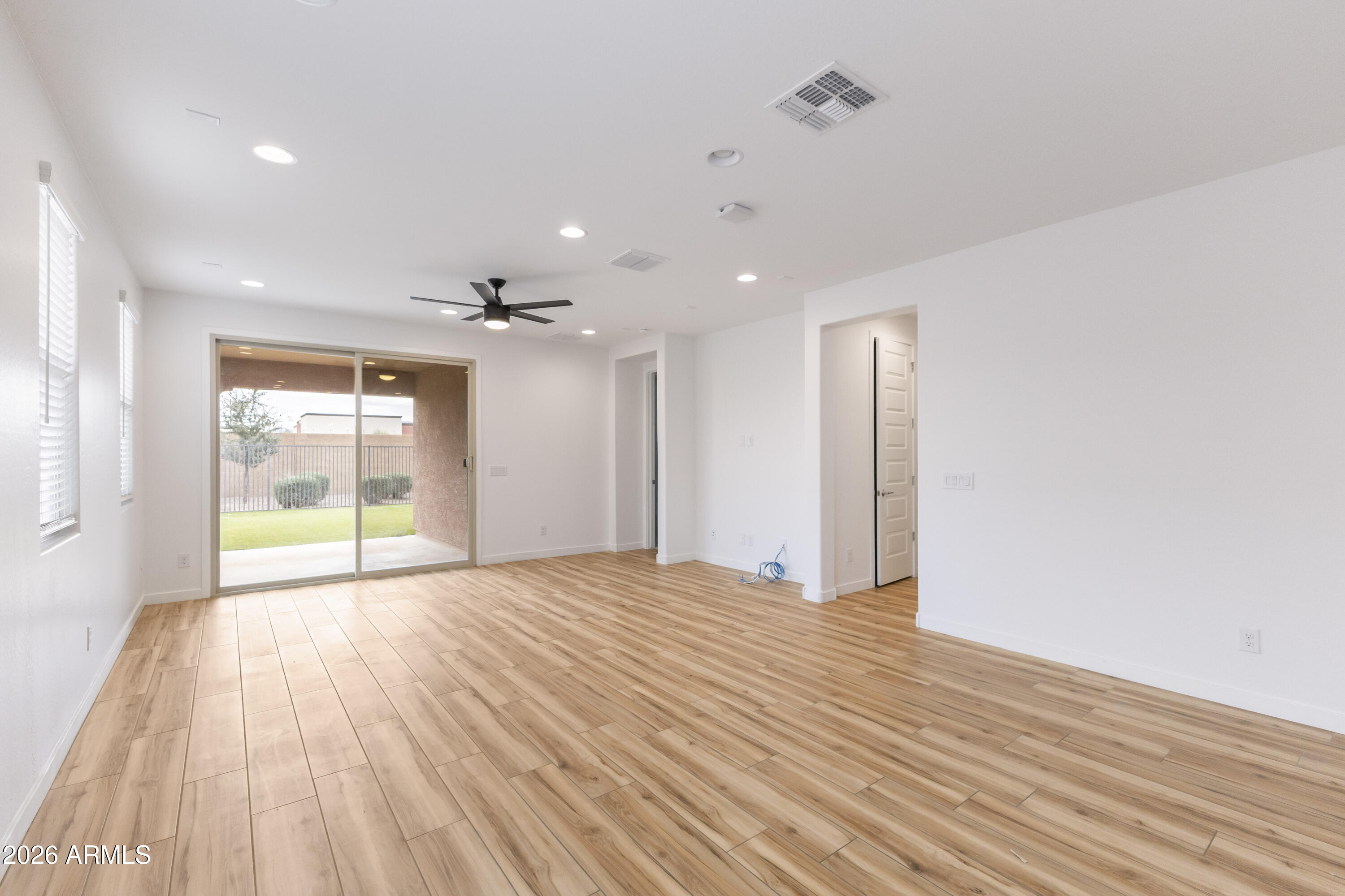 21303 East Estrella Road Queen Creek, AZ 85142 - Photo 13 of 32 a view of an empty room with wooden floor and a window