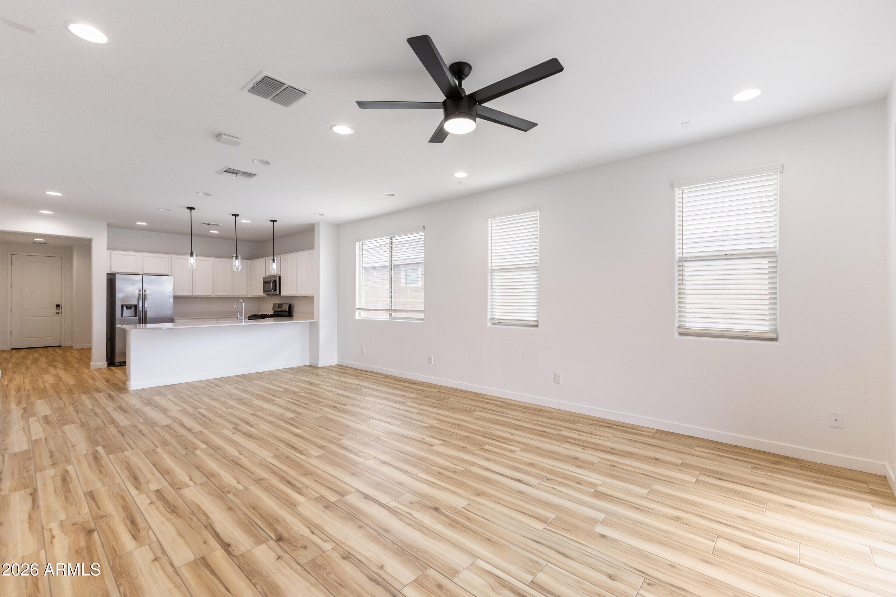 21303 East Estrella Road Queen Creek, AZ 85142 - Photo 15 of 32 a view of kitchen and empty room with wooden floor