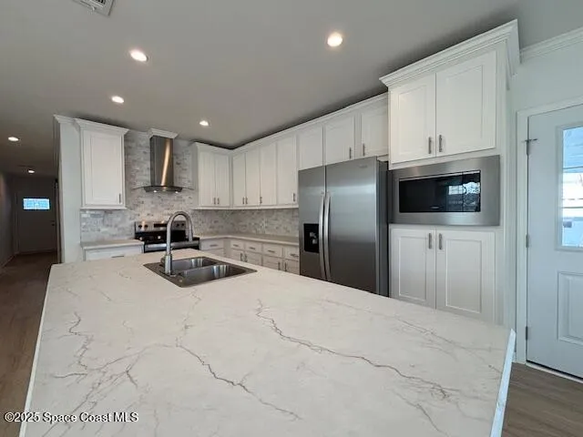 a kitchen with stainless steel appliances a refrigerator sink and microwave