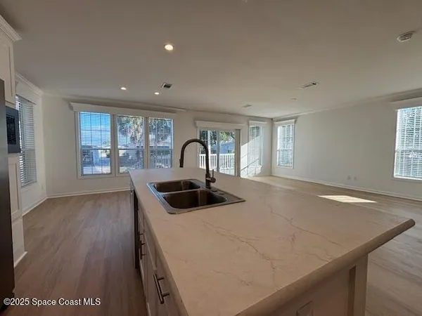 a kitchen with a sink and wooden floor