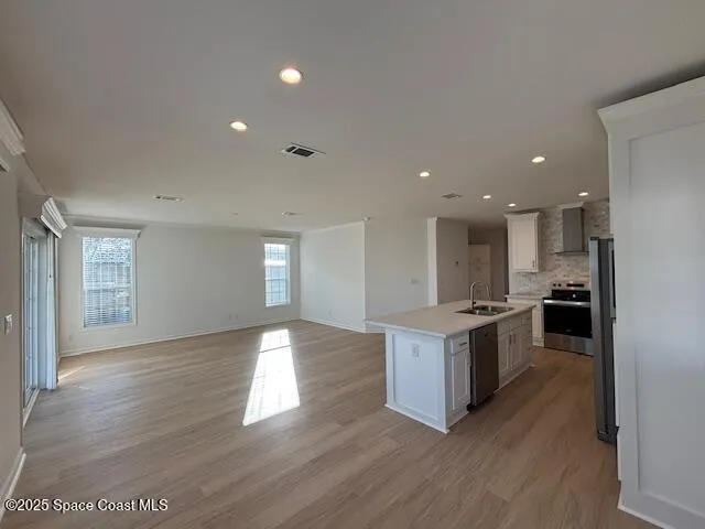a kitchen with a stove and wooden floor