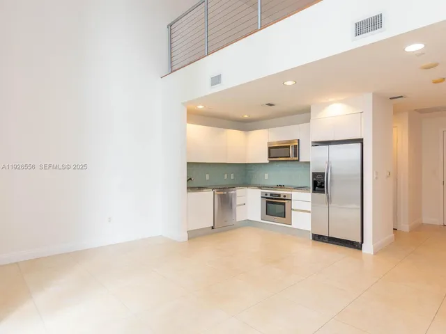 a large kitchen with stainless steel appliances a large counter top