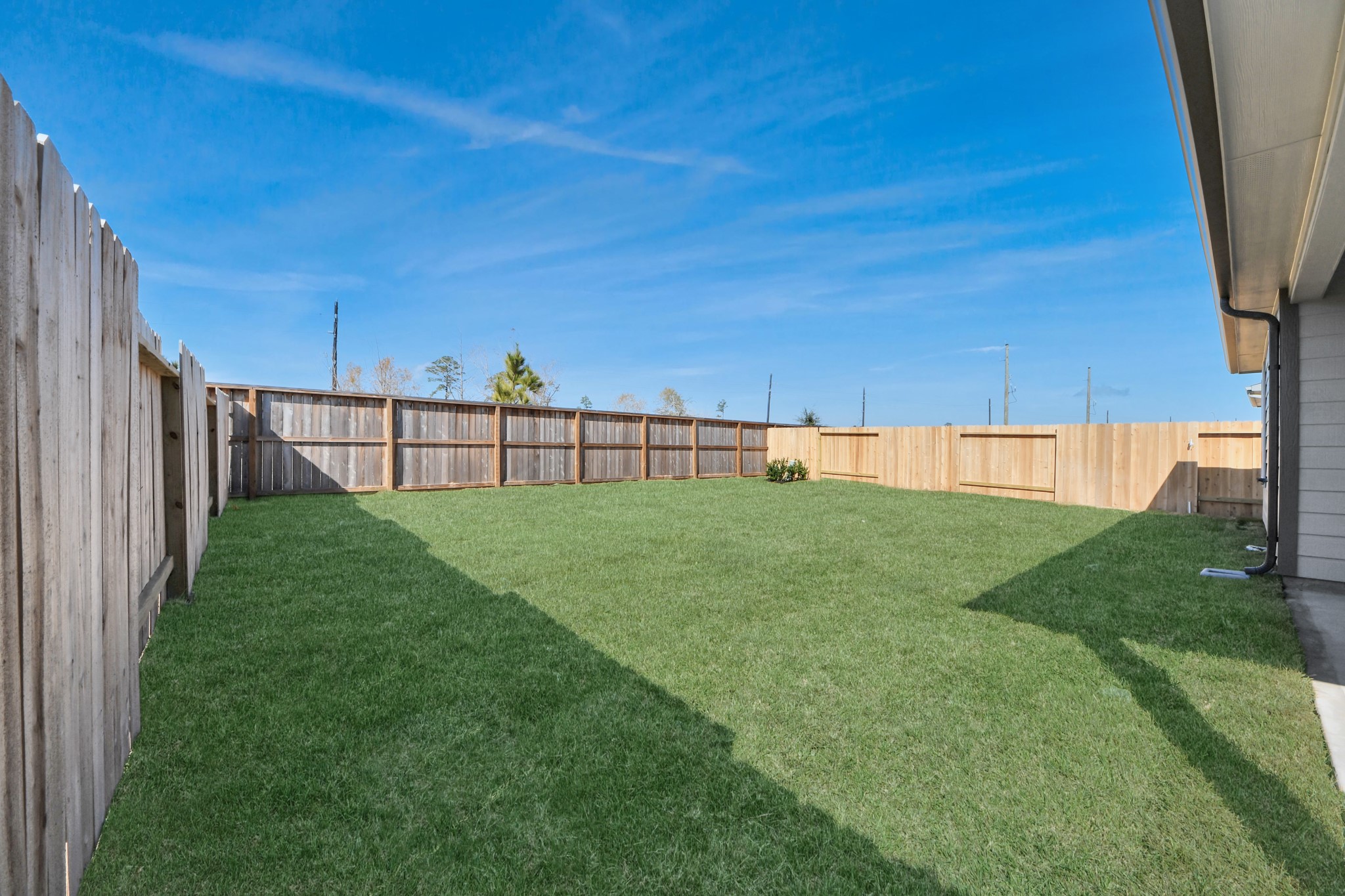 311 Ice Shr Trail Dayton, TX 77535 - Photo 35 of 35 Backyard retreat, offering an abundance of space for kids to play and explore. The possibilities are endless in this outdoor haven, where the joy of open-air activities and family gatherings awaits. Sample photo of completed home with similar floor plan. Actual colors and selections may vary.