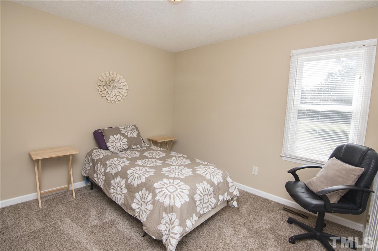 1849 Sanders Road Willow Spring, NC 27592 - Photo 14 of 25 a bedroom with a bed and chair