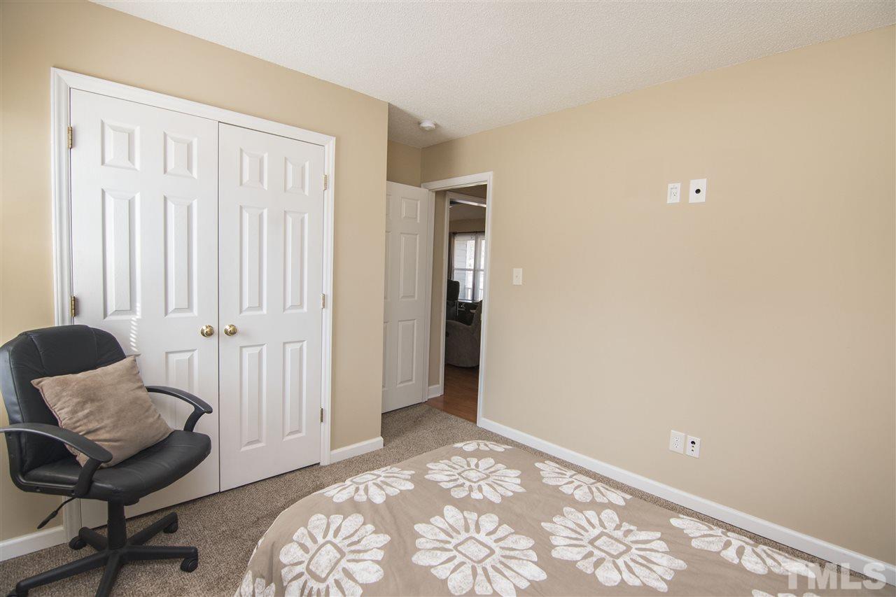 1849 Sanders Road Willow Spring, NC 27592 - Photo 15 of 25 a view of a bedroom with wooden floor and a window