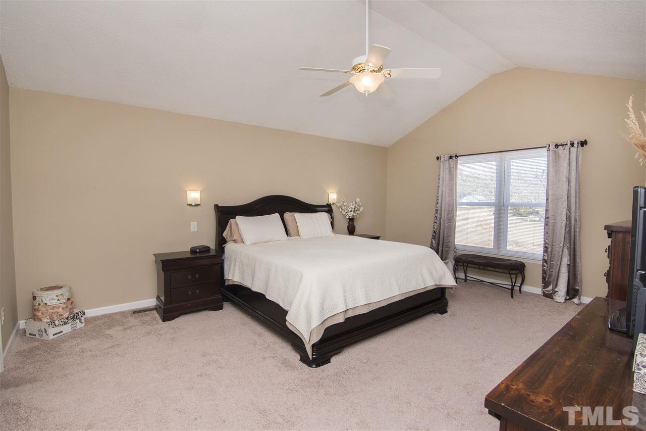 1849 Sanders Road Willow Spring, NC 27592 - Photo 16 of 25 a bedroom with a bed lamp and a window