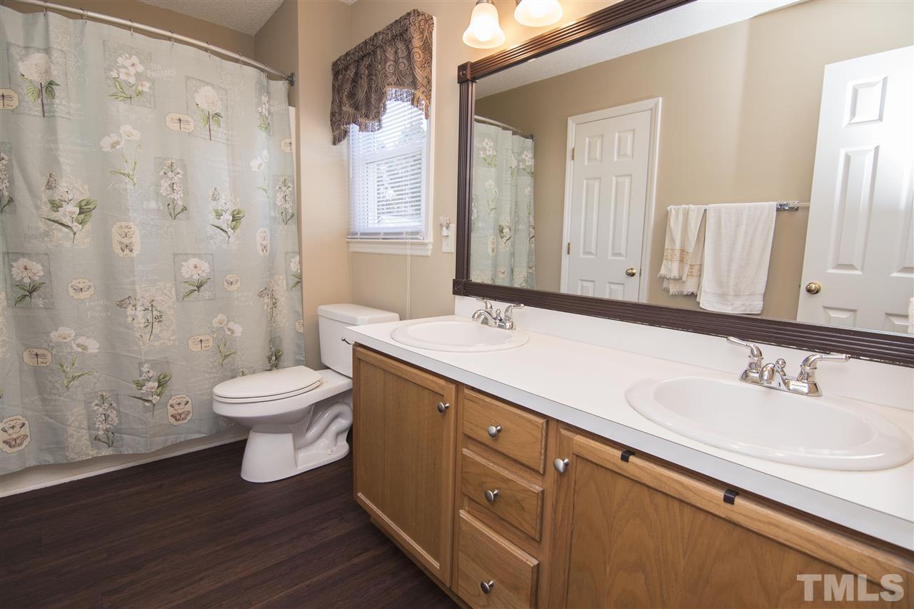 1849 Sanders Road Willow Spring, NC 27592 - Photo 18 of 25 a bathroom with a sink a toilet and shower