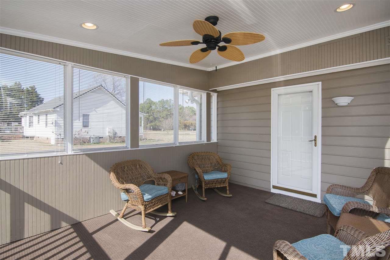 1849 Sanders Road Willow Spring, NC 27592 - Photo 22 of 25 a living room with a window wooden floor and a table