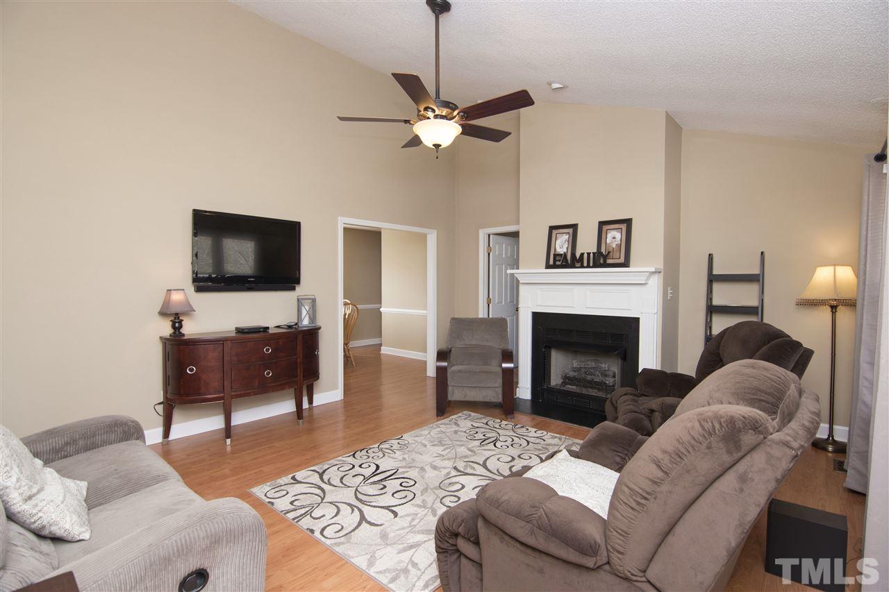 1849 Sanders Road Willow Spring, NC 27592 - Photo 5 of 25 a living room with furniture a flat screen tv and a fireplace