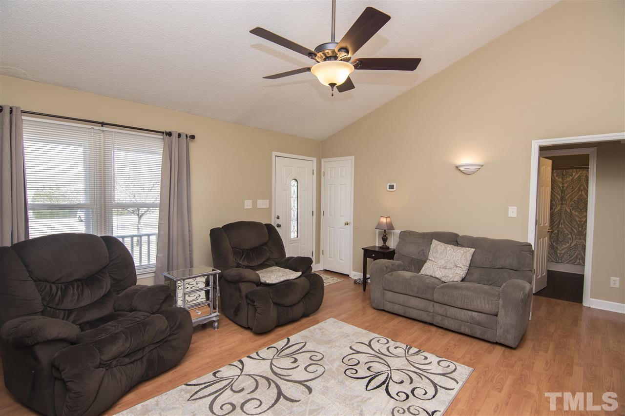 1849 Sanders Road Willow Spring, NC 27592 - Photo 6 of 25 a living room with furniture ceiling fan and a window
