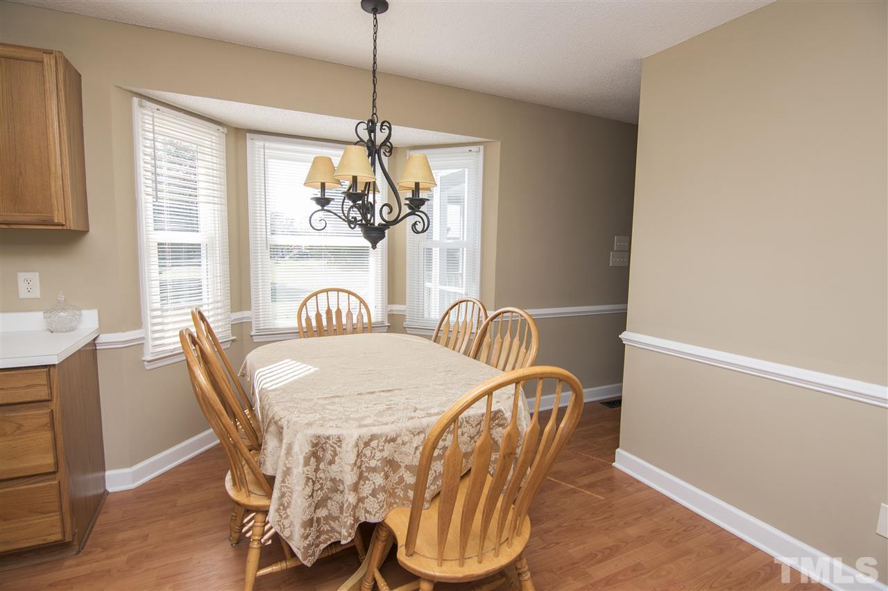 1849 Sanders Road Willow Spring, NC 27592 - Photo 7 of 25 a view of a dining room with furniture a chandelier and wooden floor