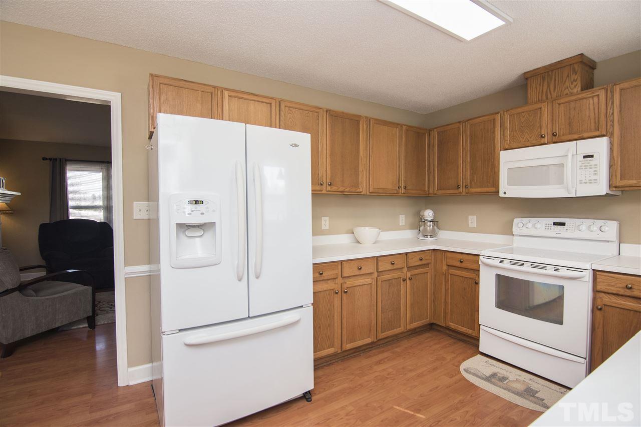 1849 Sanders Road Willow Spring, NC 27592 - Photo 10 of 25 a kitchen with stainless steel appliances granite countertop a refrigerator sink and stove