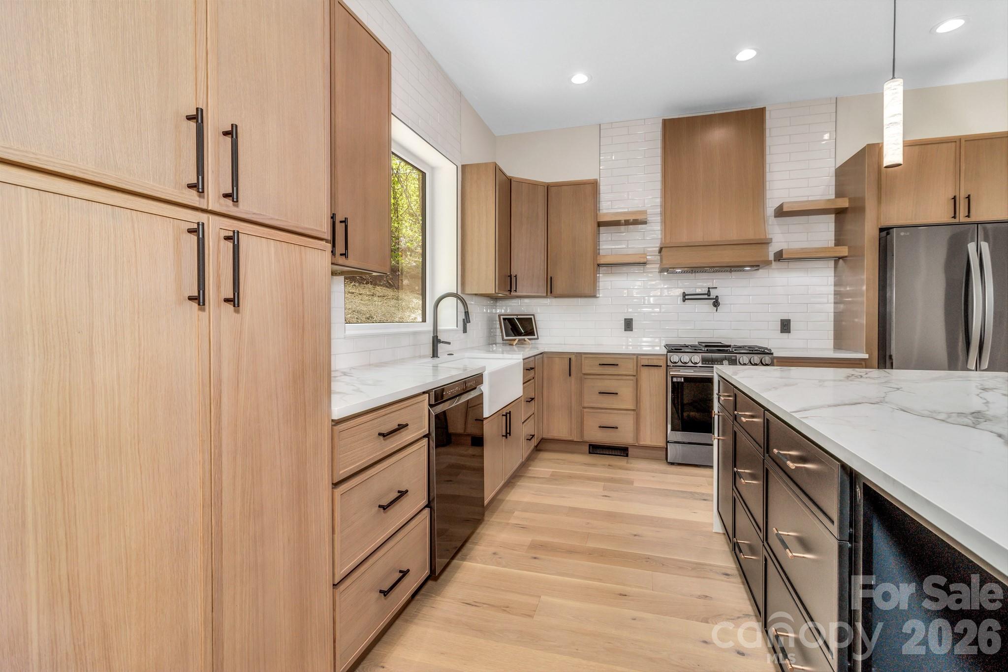 134 View Ridge Parkway Leicester, NC 28748 - Photo 14 of 48 a large kitchen with stainless steel appliances sink a microwave and cabinets