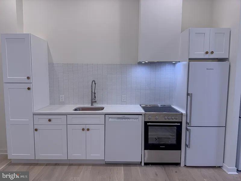 2011 Green Street, Unit 2R Philadelphia, PA 19130 - Photo 11 of 15 a kitchen with white cabinets and white appliances