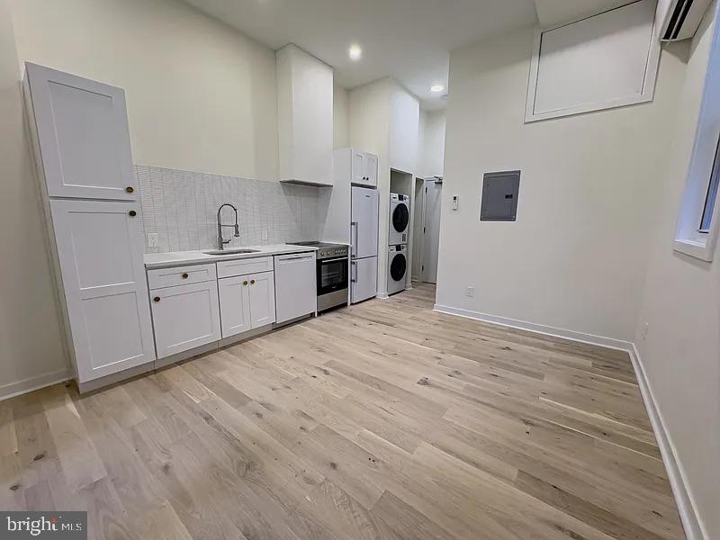 2011 Green Street, Unit 2R Philadelphia, PA 19130 - Photo 7 of 15 a large white kitchen with kitchen island a sink stainless steel appliances and cabinets