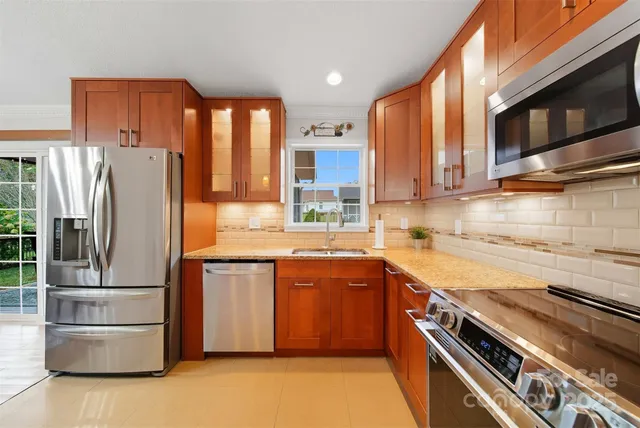 a kitchen with stainless steel appliances granite countertop a refrigerator stove and microwave