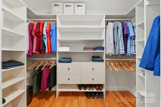 a view of walk in closet with clothes and shoes