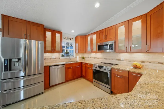a kitchen with stainless steel appliances granite countertop a refrigerator sink and cabinets