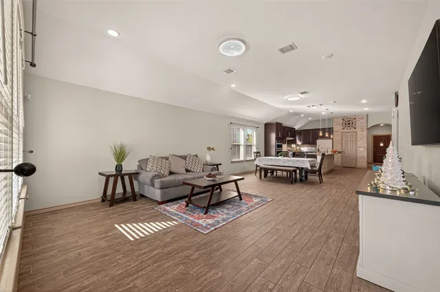 a living room with furniture and a wooden floor