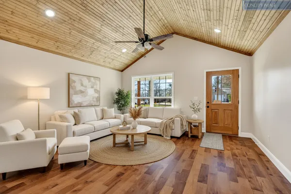 a living room with furniture and a wooden floor