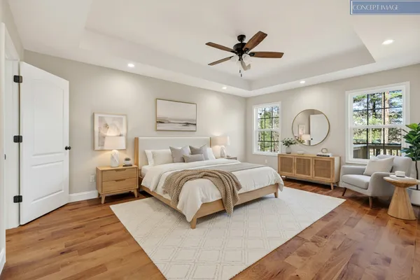 a spacious bedroom with a bed a couch and large window