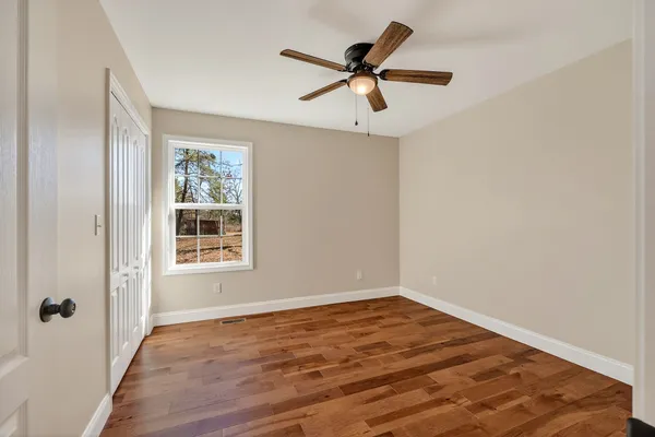 a view of a big room with wooden floor closet and windows