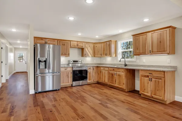 a kitchen with stainless steel appliances granite countertop a refrigerator and a stove top oven