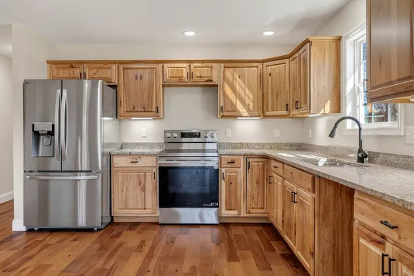 a kitchen with stainless steel appliances granite countertop a refrigerator and a sink