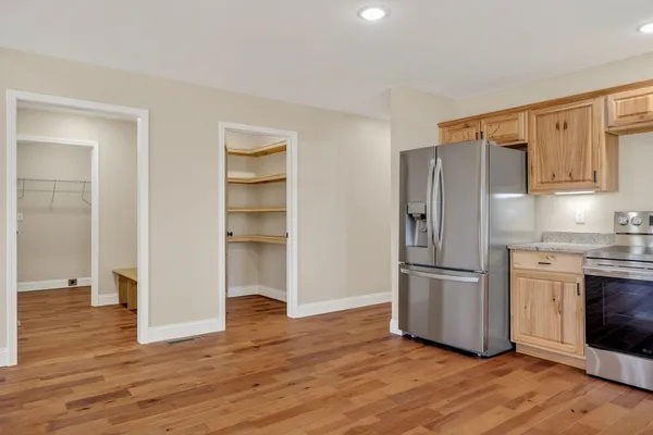 a kitchen with a refrigerator and a stove top oven
