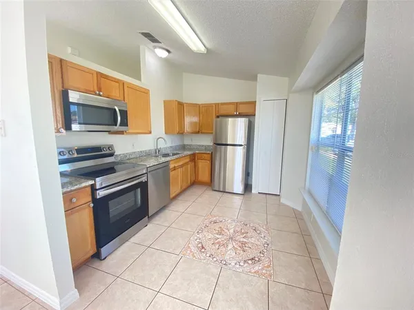 a kitchen with stainless steel appliances granite countertop a refrigerator and a stove top oven