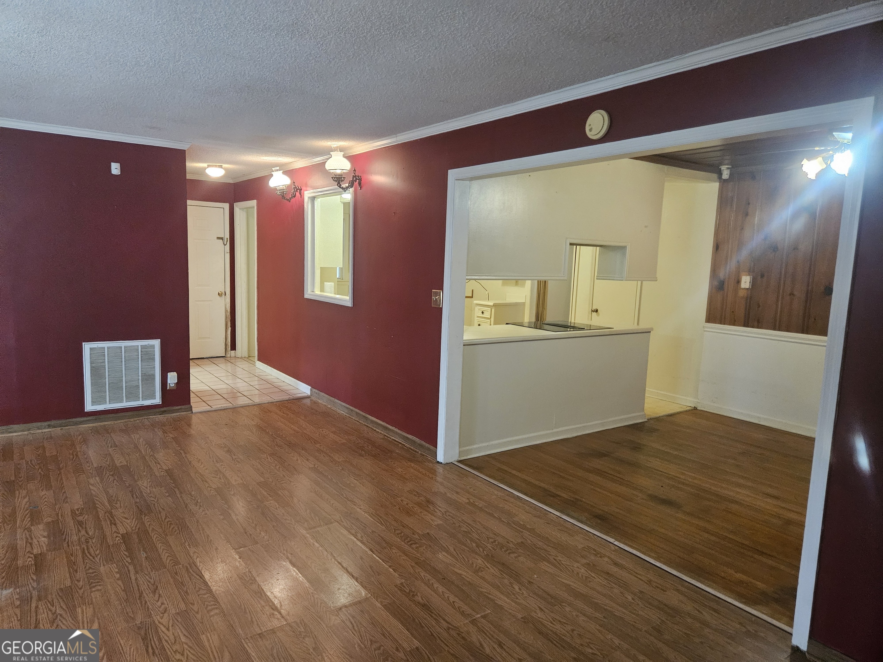 846 Harvey Street Millen, GA 30442 - Photo 13 of 34 a view of an empty room with wooden floor and a kitchen