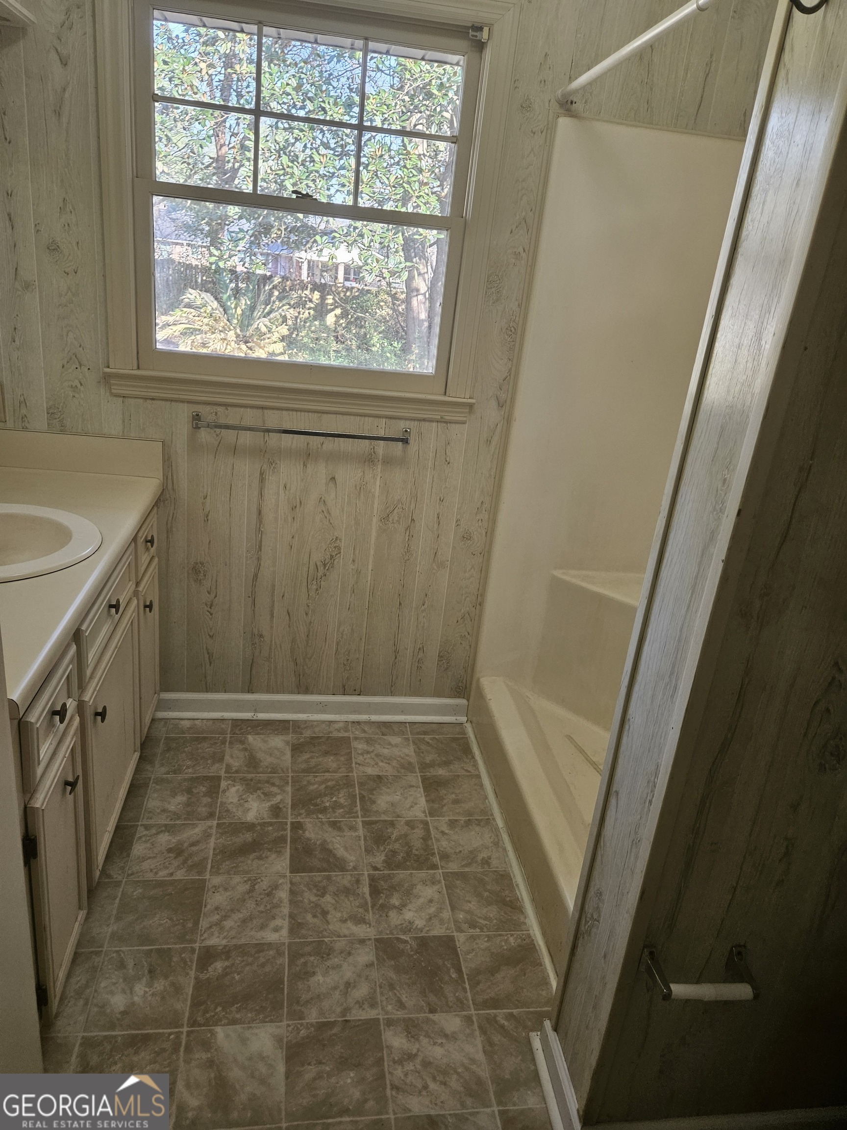 846 Harvey Street Millen, GA 30442 - Photo 20 of 34 a bathroom with a granite countertop sink a toilet a window a shower and vanity