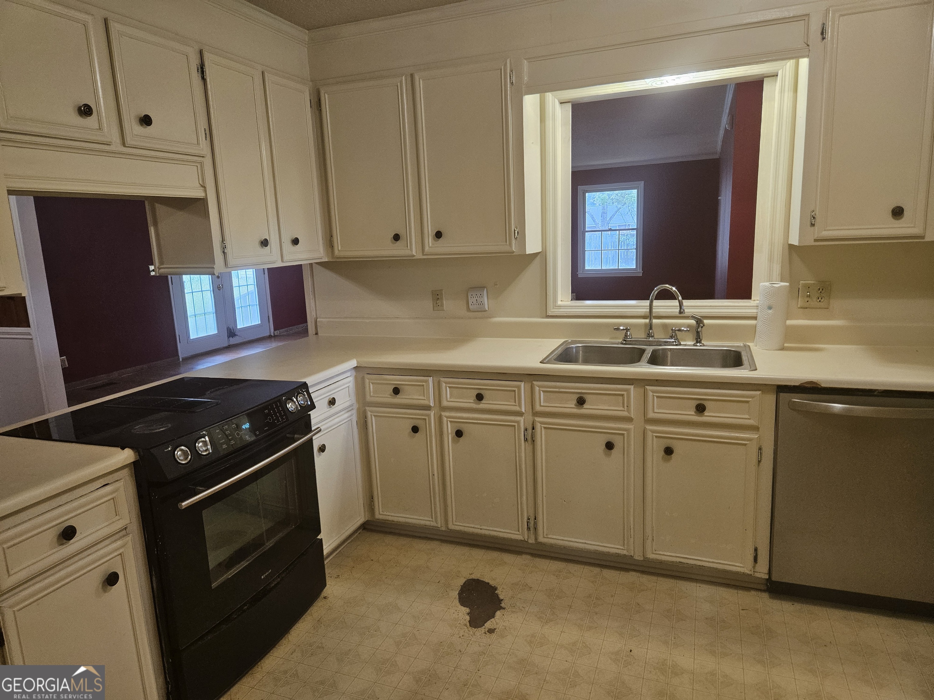 846 Harvey Street Millen, GA 30442 - Photo 6 of 34 a kitchen with white cabinets and black appliances