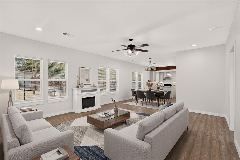 304 East County Line Road Royse City, TX 75189 - Photo 7 of 38 Open-concept living space with wood-finish flooring, a white fireplace surround, multiple windows, recessed lighting, and a ceiling fan