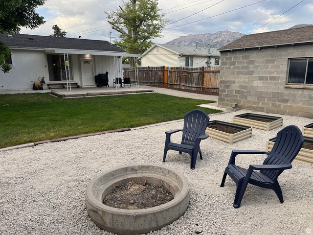 1791 West 170 South, Unit 8 Provo, UT 84601 - Photo 19 of 25 Expansive outdoor space featuring a fire pit area with gravel ground cover, an adjacent grassy lawn, and raised garden beds