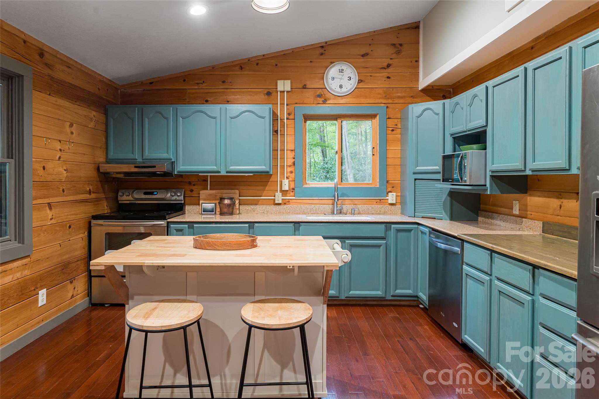 4035 Bald Creek Road Clyde, NC 28721 - Photo 12 of 43 a kitchen with stainless steel appliances granite countertop a sink a microwave cabinets and a dining table